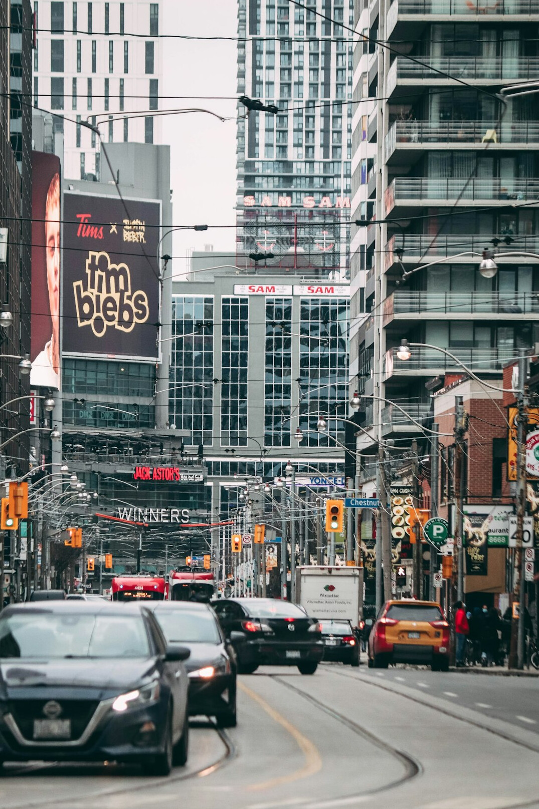 Cars moving along a downtown Toronto street between high rise buildings